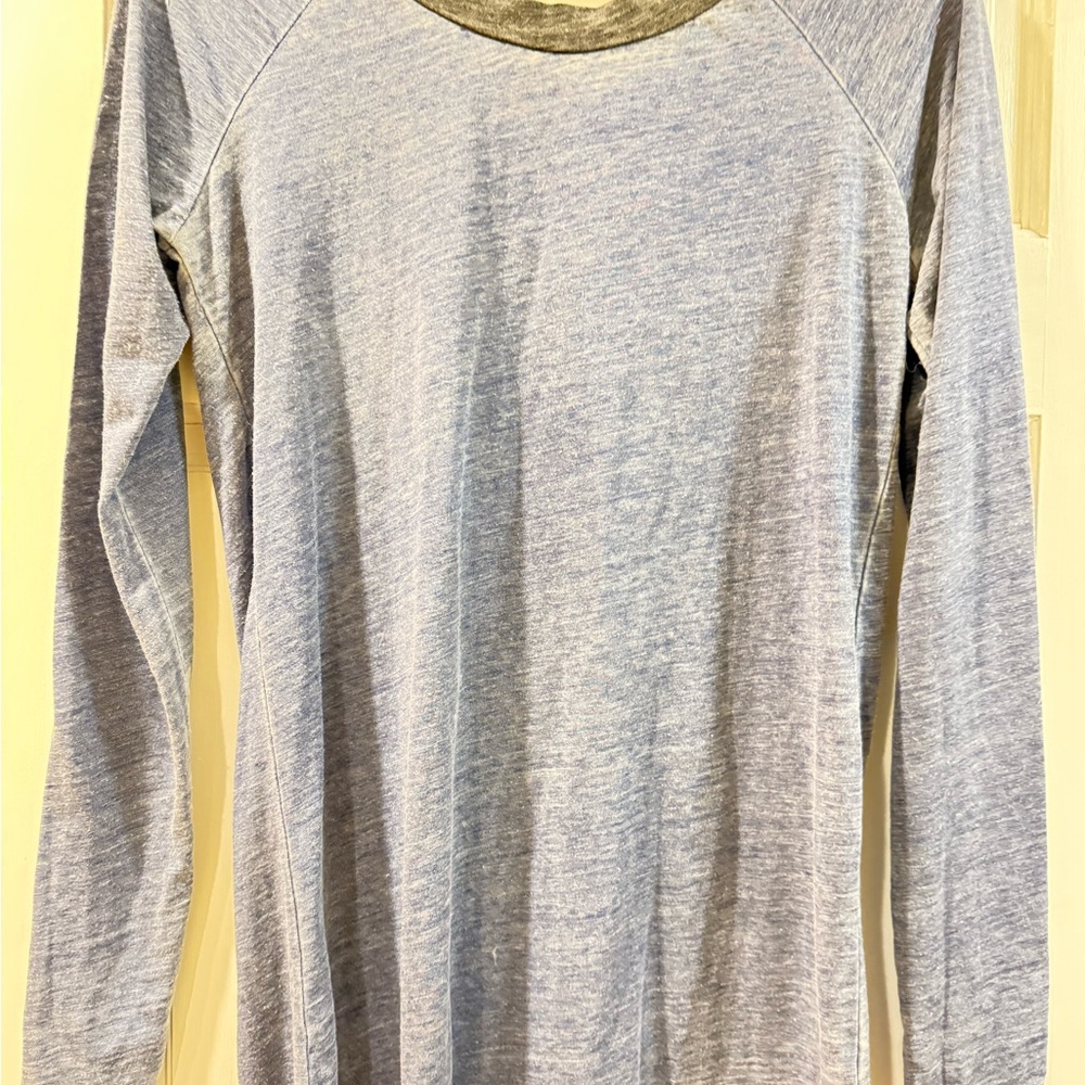 Blue long sleeve shirt with black around neck . Open in back